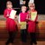 Drei Kinder in roter Kleidung mit Urkunden