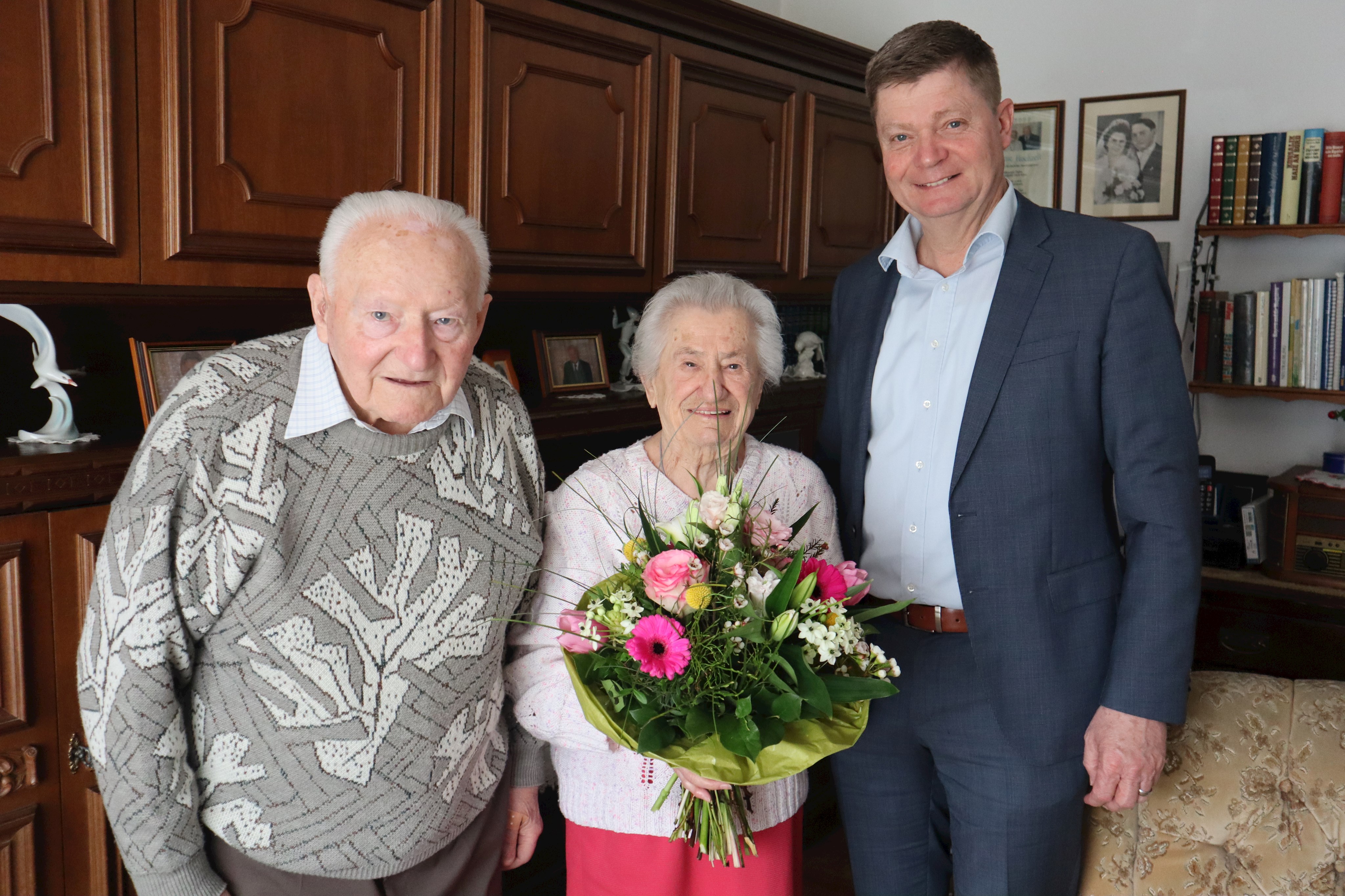 Ehepaar Glöckl mit Blumenstrauß und Bürgermeister